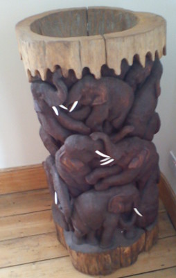 Wooden column of carved elephants, each with white tusks